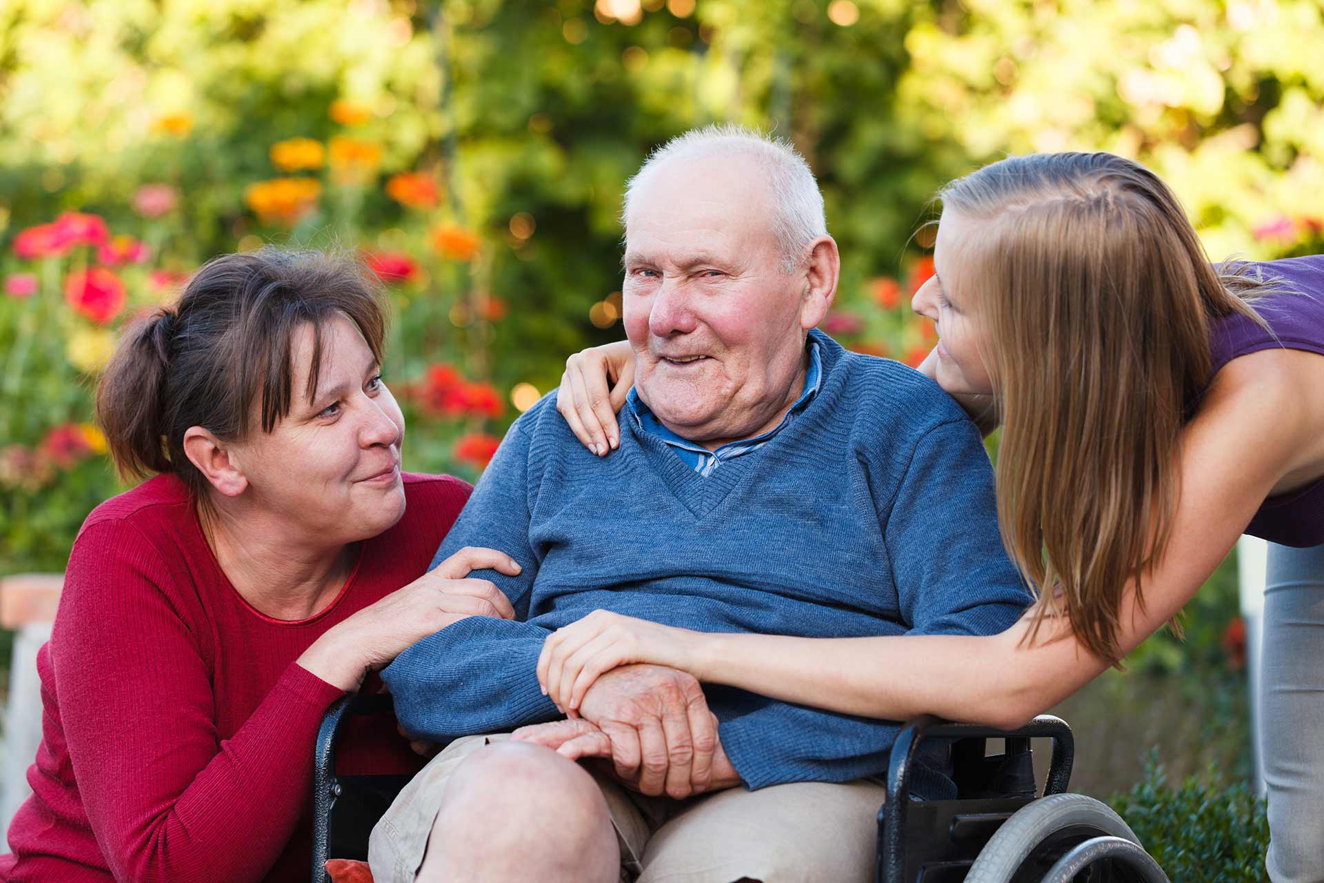 Person in wheelchair with carers